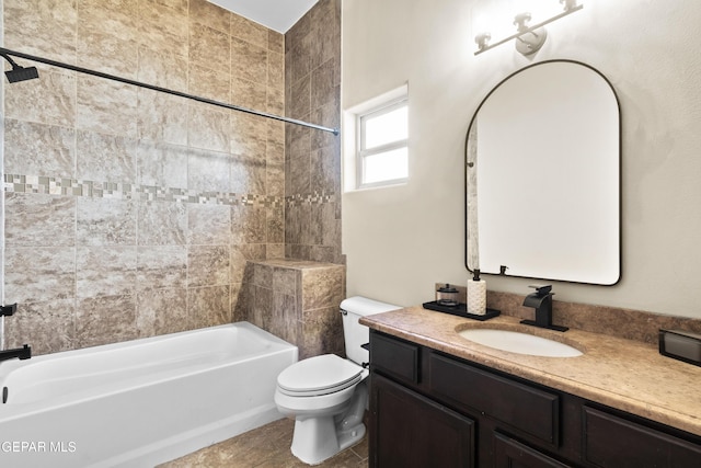 full bathroom featuring tiled shower / bath, vanity, toilet, and tile patterned floors