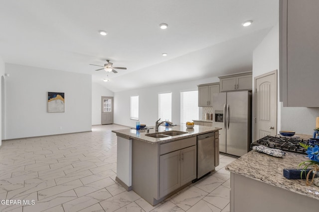 kitchen with ceiling fan, sink, lofted ceiling, a center island with sink, and appliances with stainless steel finishes