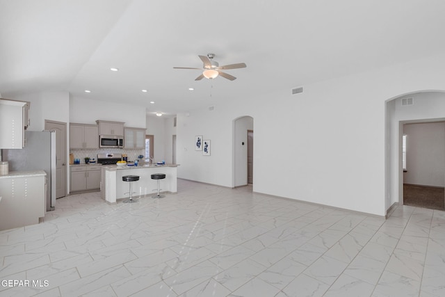 unfurnished living room featuring ceiling fan and vaulted ceiling