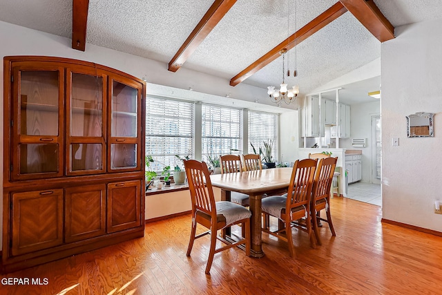 dining space featuring lofted ceiling with beams, an inviting chandelier, a textured ceiling, and light hardwood / wood-style flooring