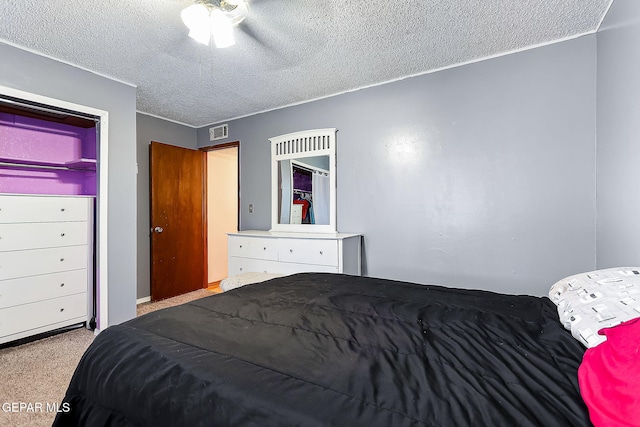 carpeted bedroom featuring ceiling fan and a textured ceiling