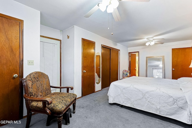 bedroom featuring light carpet, two closets, and ceiling fan