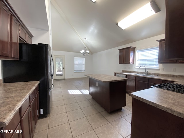 kitchen featuring an inviting chandelier, black fridge, sink, light tile patterned floors, and a kitchen island