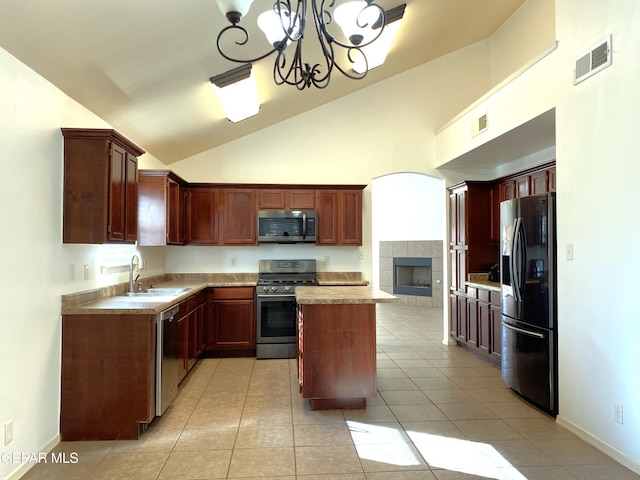 kitchen featuring sink, decorative light fixtures, a notable chandelier, a kitchen island, and stainless steel appliances