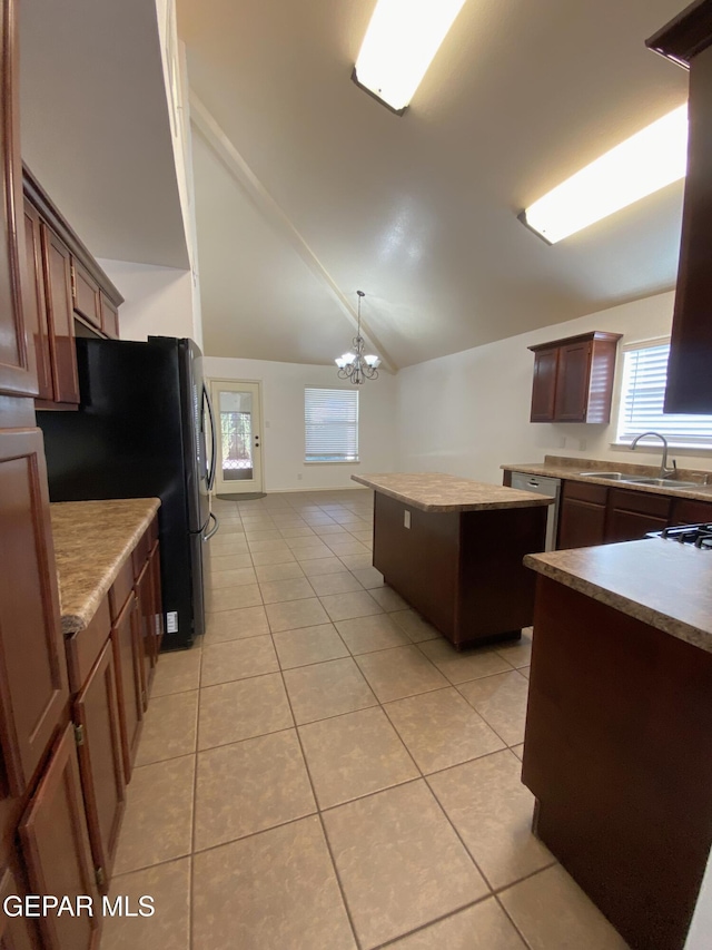 kitchen with an inviting chandelier, sink, hanging light fixtures, a kitchen island, and light tile patterned flooring