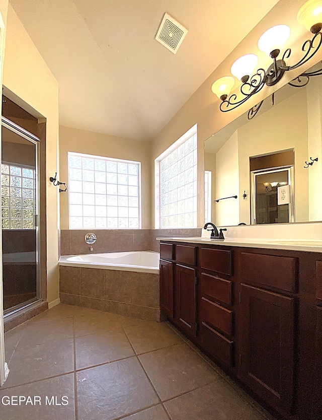 bathroom with tile patterned flooring, vanity, separate shower and tub, and vaulted ceiling