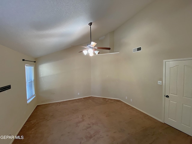 carpeted spare room featuring a textured ceiling, ceiling fan, and vaulted ceiling