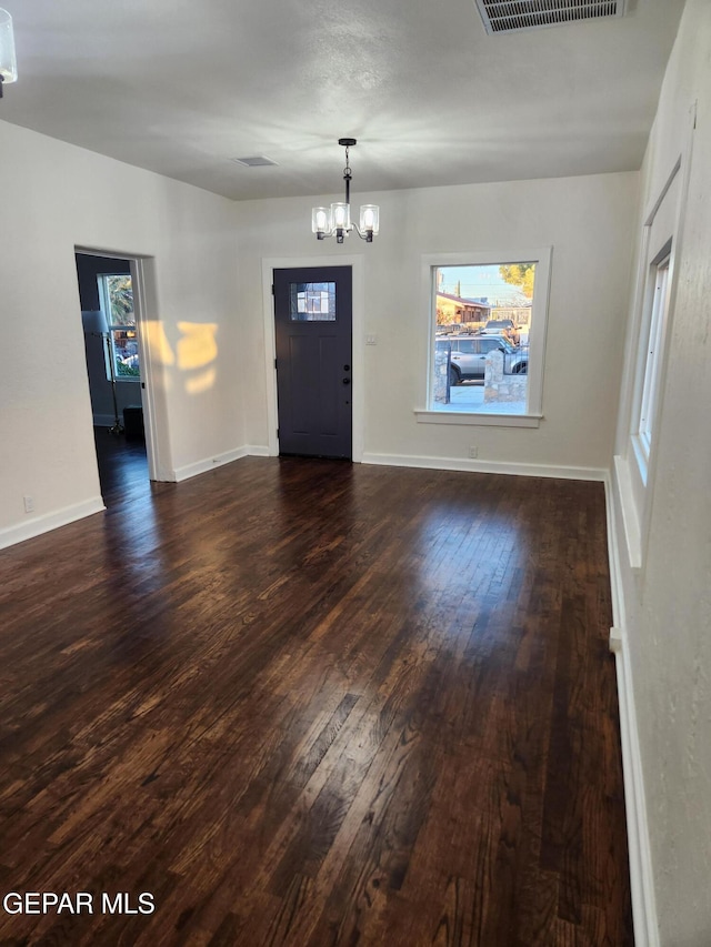 foyer with dark hardwood / wood-style floors and a chandelier