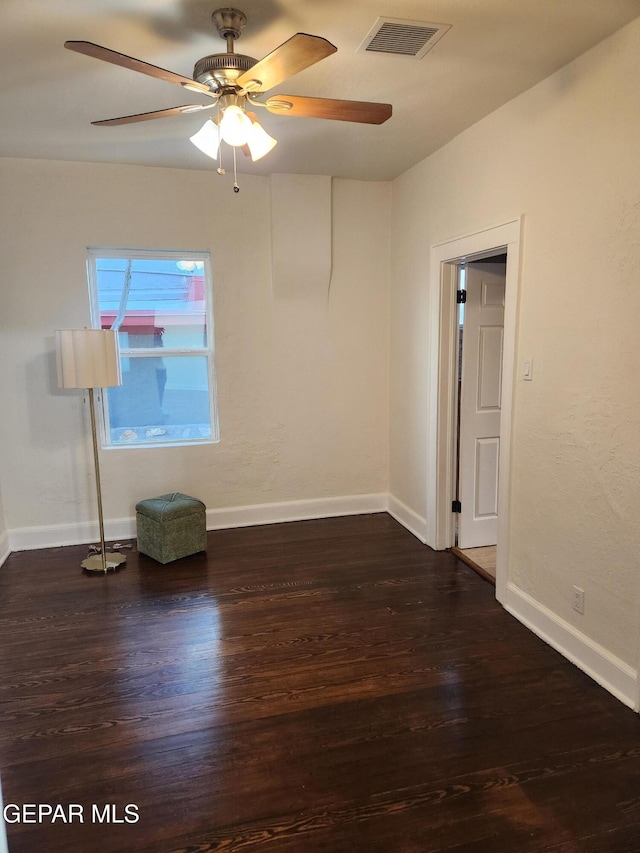 empty room with ceiling fan and dark wood-type flooring