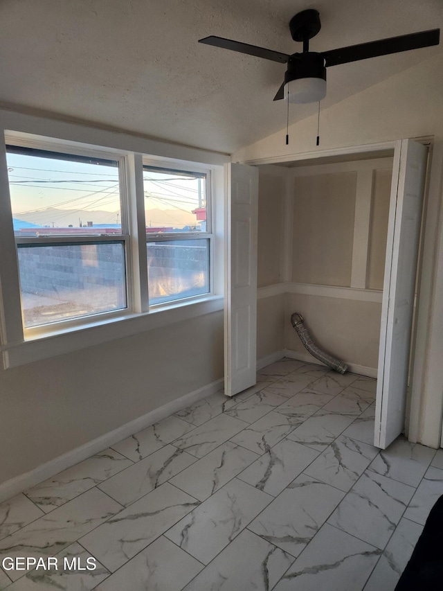 unfurnished bedroom featuring a textured ceiling, ceiling fan, and vaulted ceiling