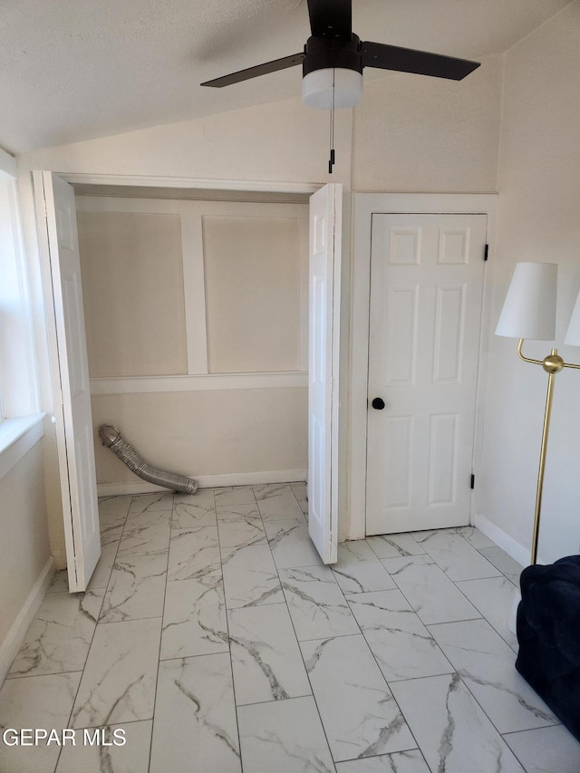 bathroom with a textured ceiling, ceiling fan, and vaulted ceiling