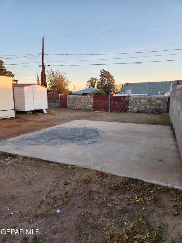 patio terrace at dusk featuring a storage unit