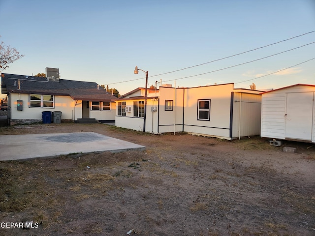 view of front facade featuring a patio area and a shed