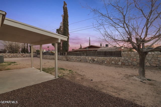 yard at dusk featuring a patio area