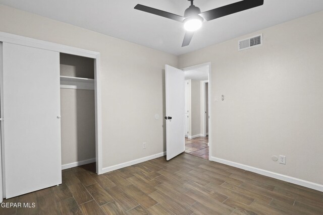 unfurnished bedroom featuring dark hardwood / wood-style flooring, a closet, and ceiling fan