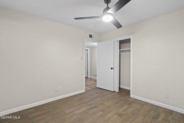 unfurnished bedroom featuring ceiling fan, dark wood-type flooring, and a closet