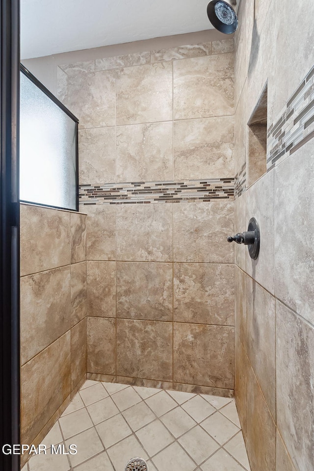 bathroom featuring tile patterned floors and a tile shower