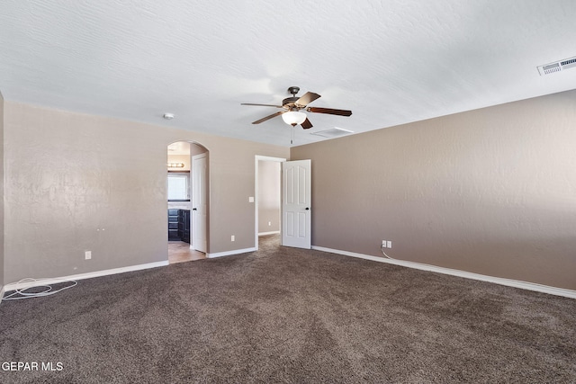 unfurnished bedroom with carpet flooring, a textured ceiling, ensuite bathroom, and ceiling fan