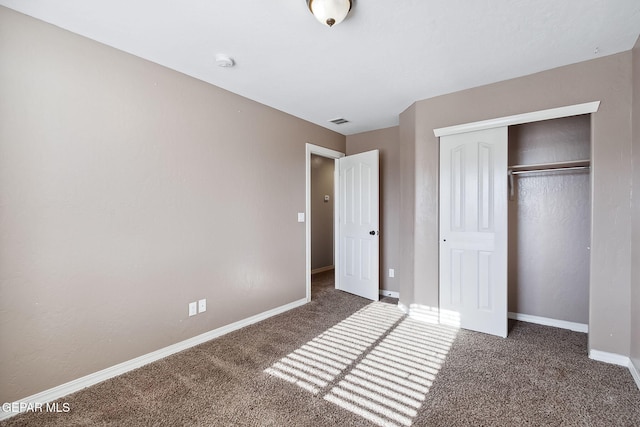 unfurnished bedroom featuring dark colored carpet and a closet