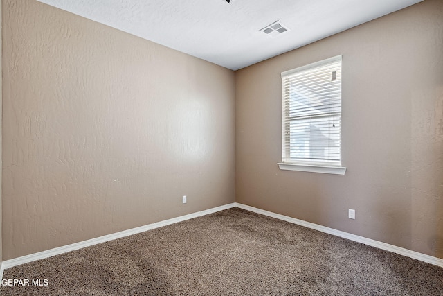 spare room with carpet and a textured ceiling