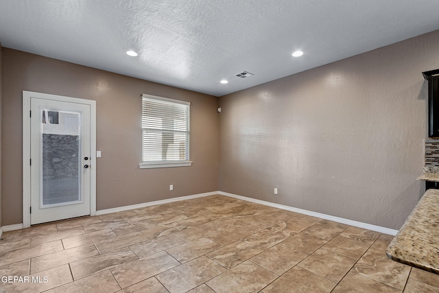 unfurnished dining area with a textured ceiling