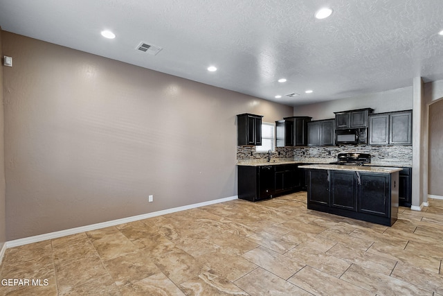 kitchen featuring black appliances, sink, light stone countertops, tasteful backsplash, and a kitchen island