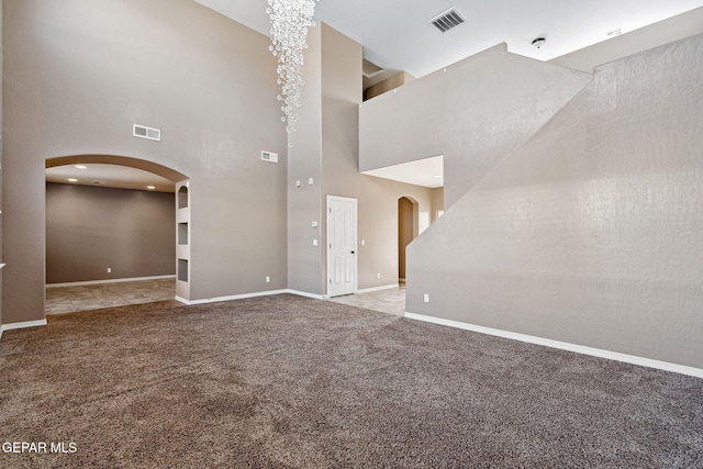 unfurnished room featuring carpet flooring and a high ceiling