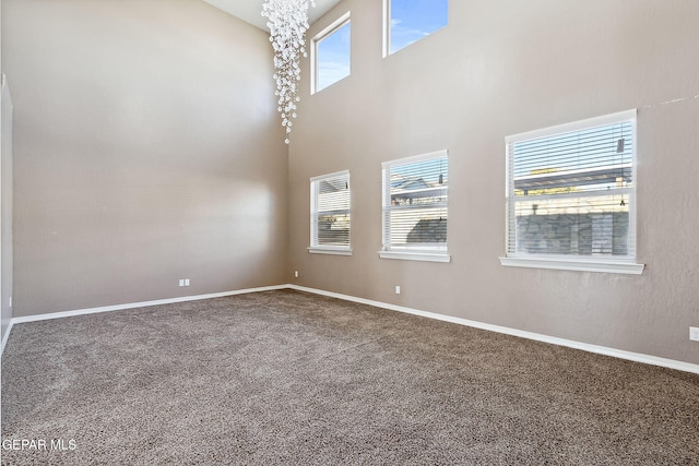 carpeted empty room with plenty of natural light and a high ceiling