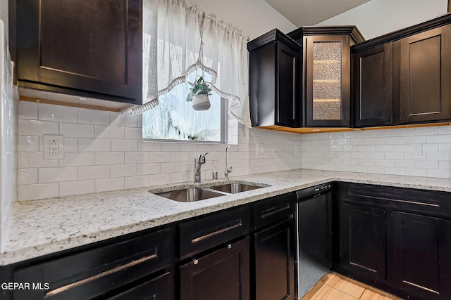 kitchen with decorative backsplash, light tile patterned floors, black dishwasher, and sink