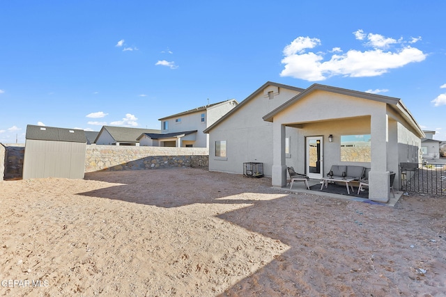 rear view of house with a patio area, an outdoor hangout area, and a shed