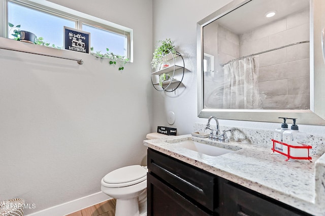 bathroom with curtained shower, hardwood / wood-style floors, vanity, and toilet