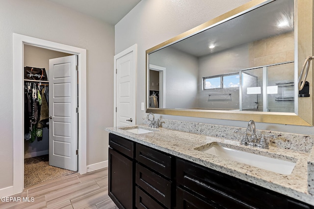 bathroom with wood-type flooring, vanity, and an enclosed shower