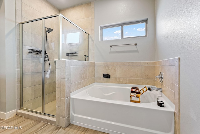 bathroom with independent shower and bath and wood-type flooring