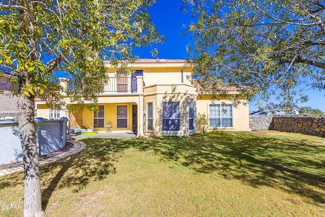 view of front of home with a patio area, a balcony, and a front lawn