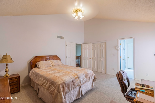 carpeted bedroom with high vaulted ceiling