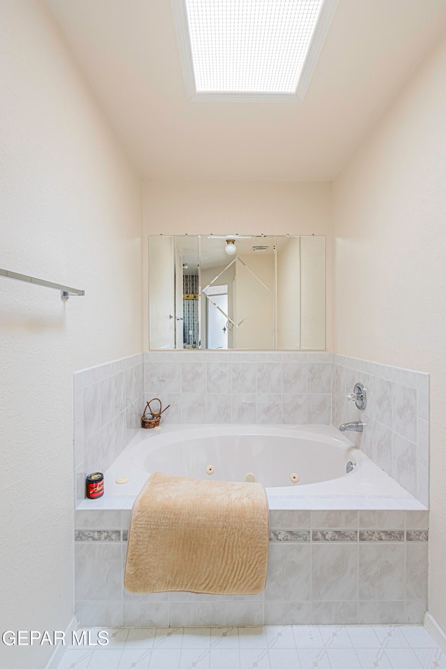 bathroom with tiled tub and tile patterned flooring