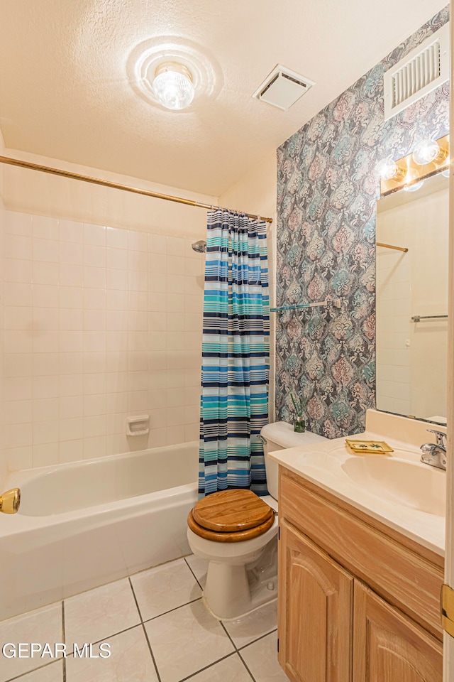 full bathroom with a textured ceiling, vanity, shower / bath combo with shower curtain, tile patterned flooring, and toilet