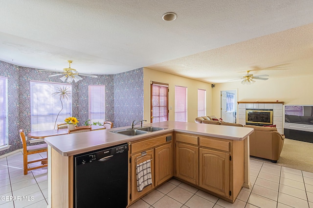 kitchen with a textured ceiling, dishwasher, light tile patterned floors, and sink