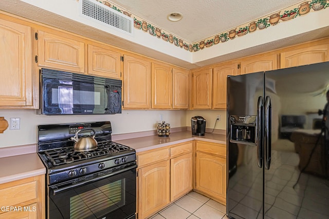 kitchen with black appliances, light tile patterned flooring, a textured ceiling, and light brown cabinets