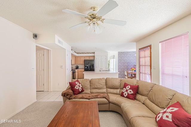 carpeted living room with ceiling fan and a textured ceiling