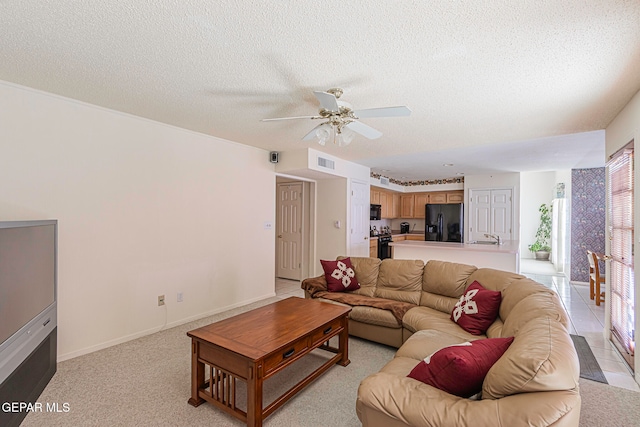 carpeted living room featuring a textured ceiling and ceiling fan