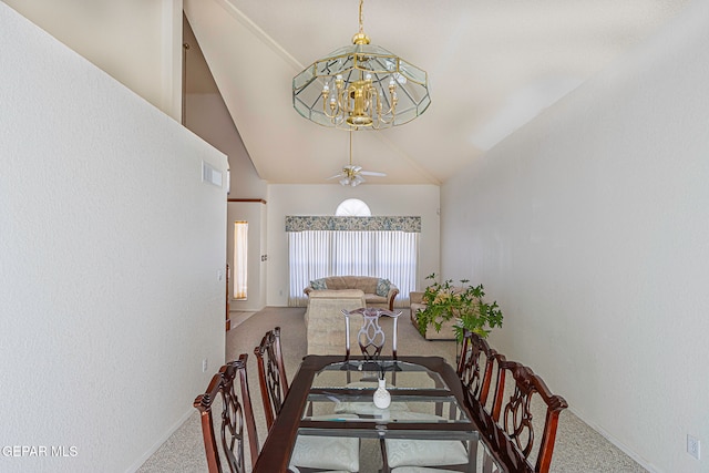 carpeted dining room with ceiling fan with notable chandelier and lofted ceiling