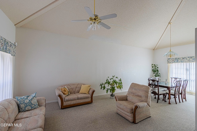 carpeted living room with a textured ceiling, vaulted ceiling, and ceiling fan