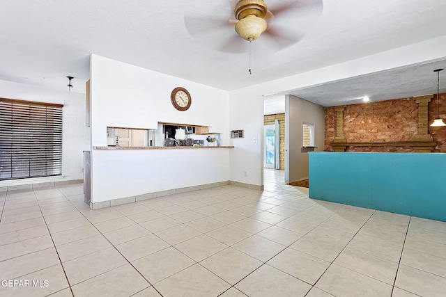 kitchen featuring ceiling fan, light tile patterned floors, a textured ceiling, and kitchen peninsula