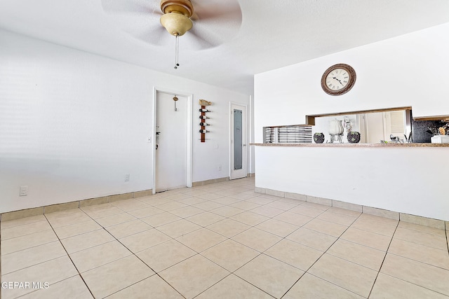 unfurnished living room with ceiling fan and light tile patterned floors