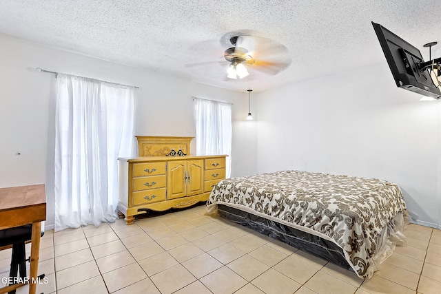 tiled bedroom with ceiling fan and a textured ceiling