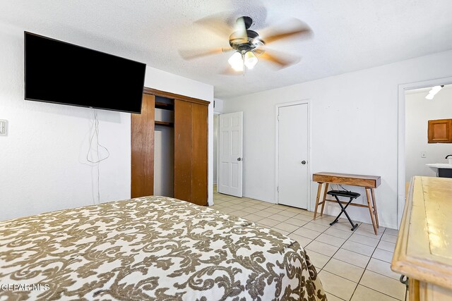 tiled bedroom featuring ceiling fan and a textured ceiling