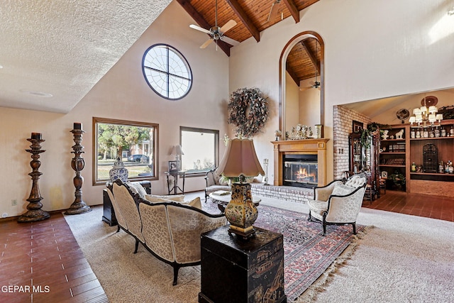 living room with hardwood / wood-style floors, high vaulted ceiling, a brick fireplace, beamed ceiling, and wood ceiling