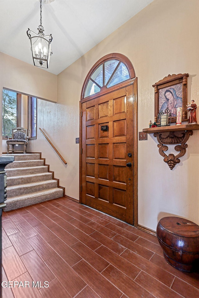 foyer entrance featuring dark wood-type flooring and a notable chandelier