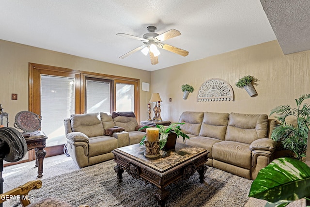 living room featuring ceiling fan and a textured ceiling